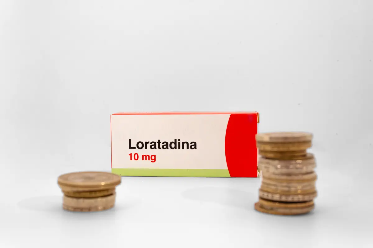 Caja de loratadina 10 mg junto a monedas colombianas